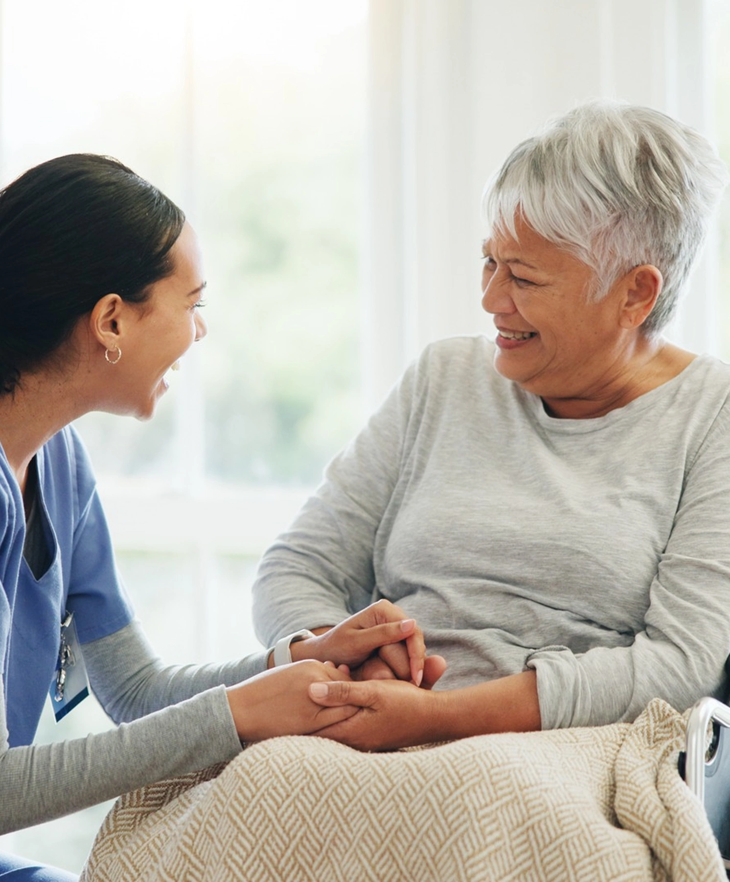 An in-home direct care worker assists a senior wheelchair user