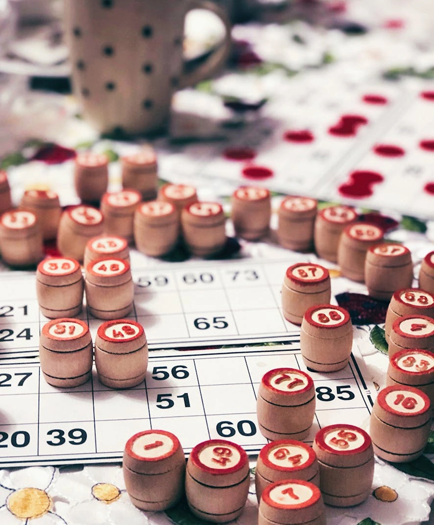 Bingo cards and wooden game pieces, arranged on a table's surface