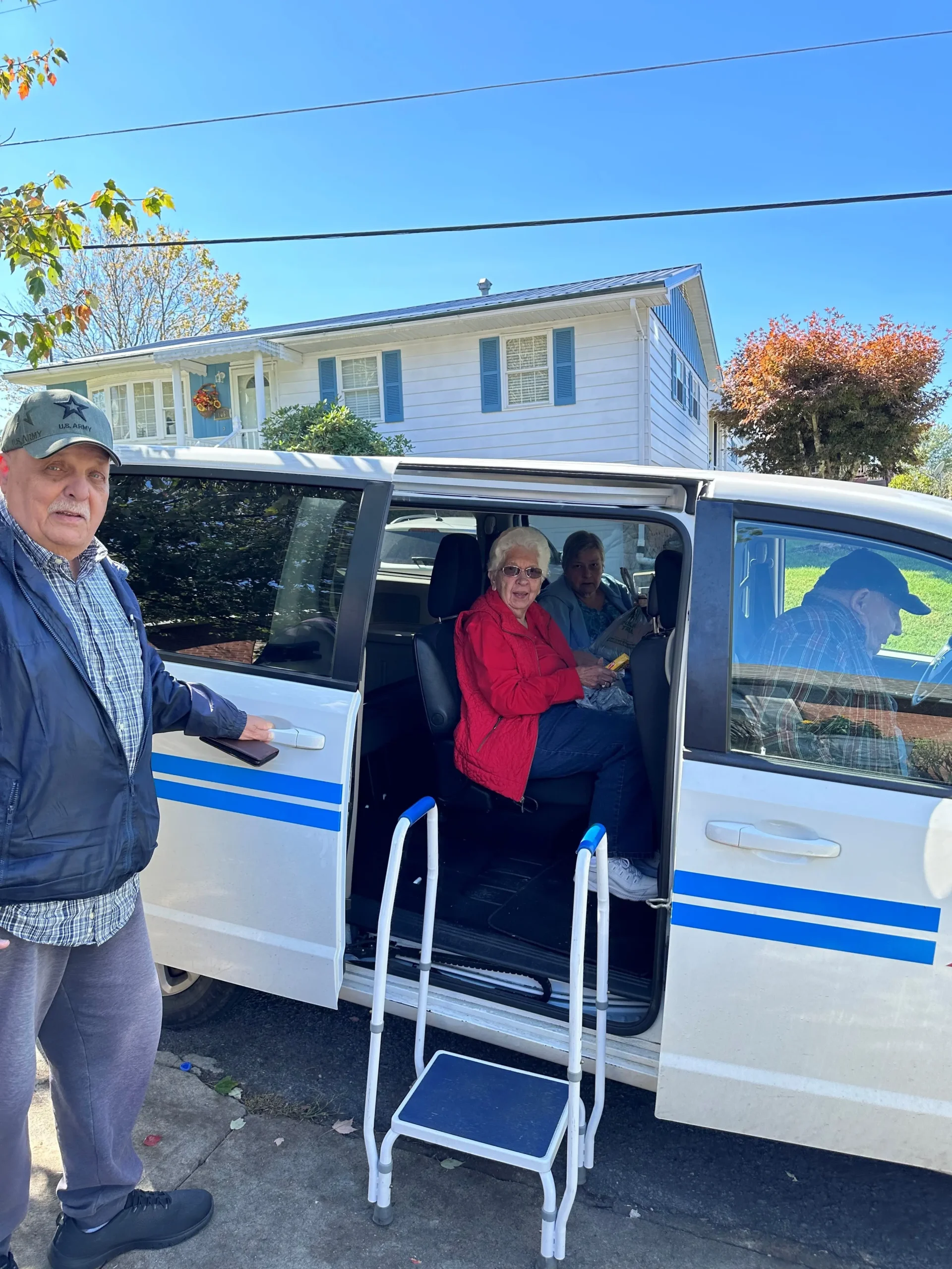 van driver helping seniors get into a van