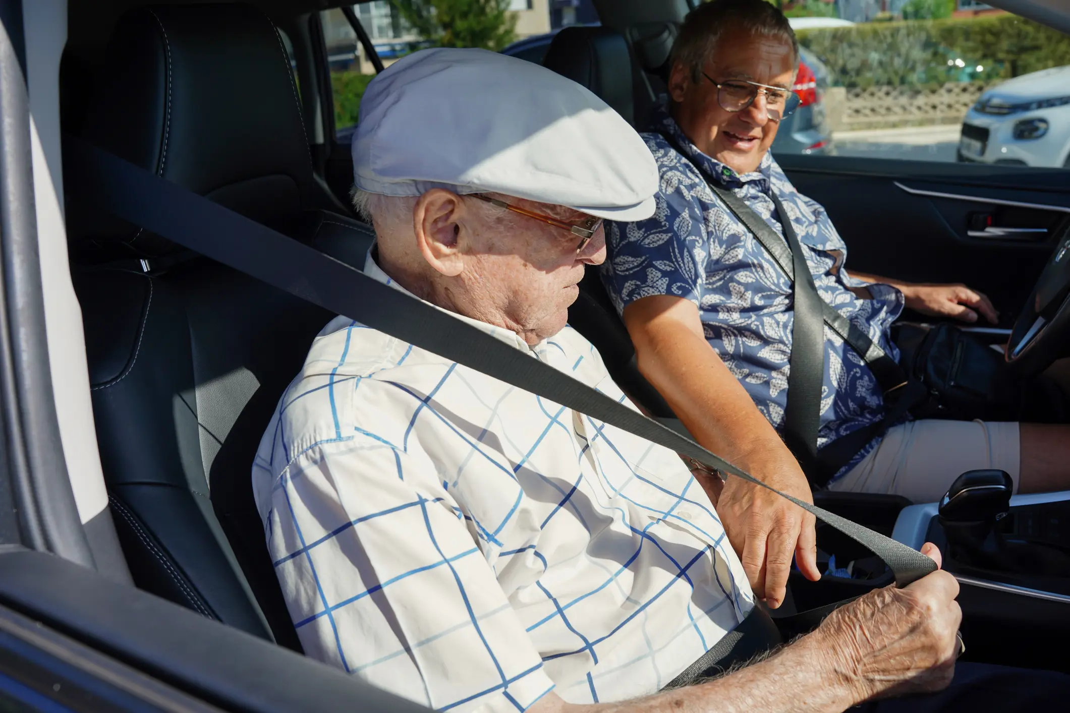 older men putting on seatbelts