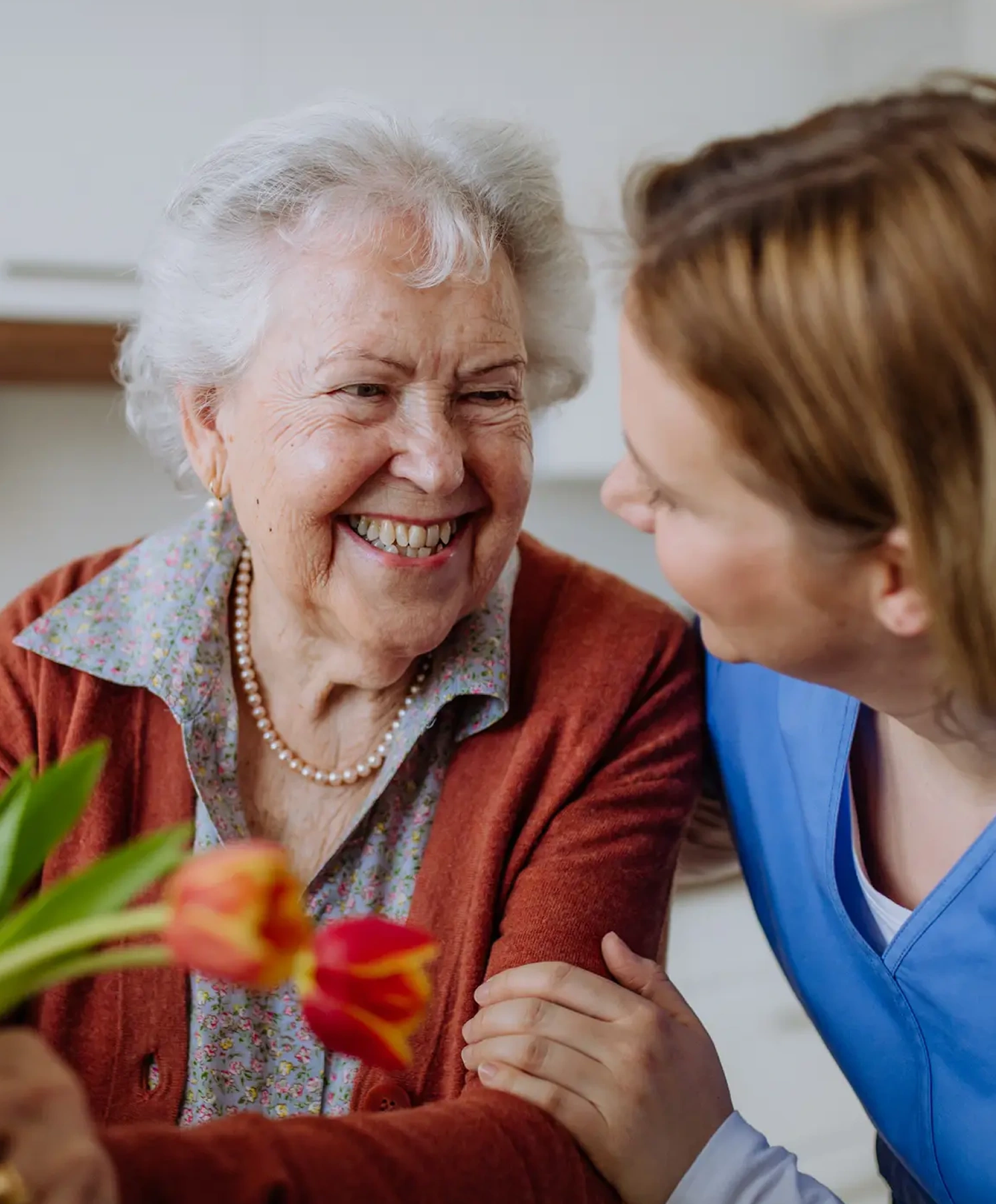 younger woman handing older woman tulips