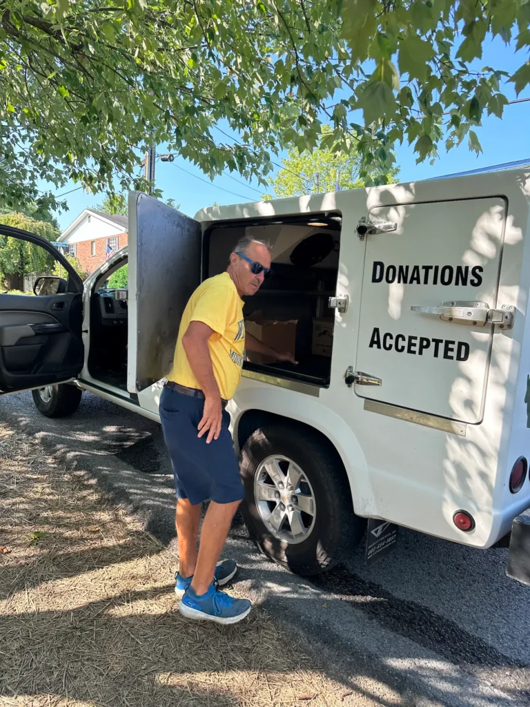 A man getting meals out of a donation van.